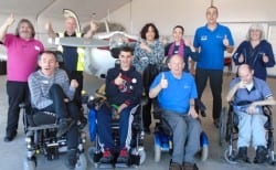 Group of guests in wheelchair and carers on accessible flying excursion