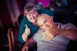 Guest and carer with thumbs up at Revitalise centre