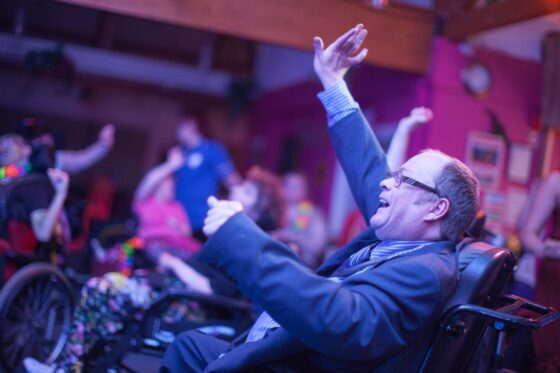 Man in wheelchair enjoying party at Revitalise Sandpipers