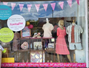 A variety of items including clothes and decor in the window display at Revitalise Gosport charity shop