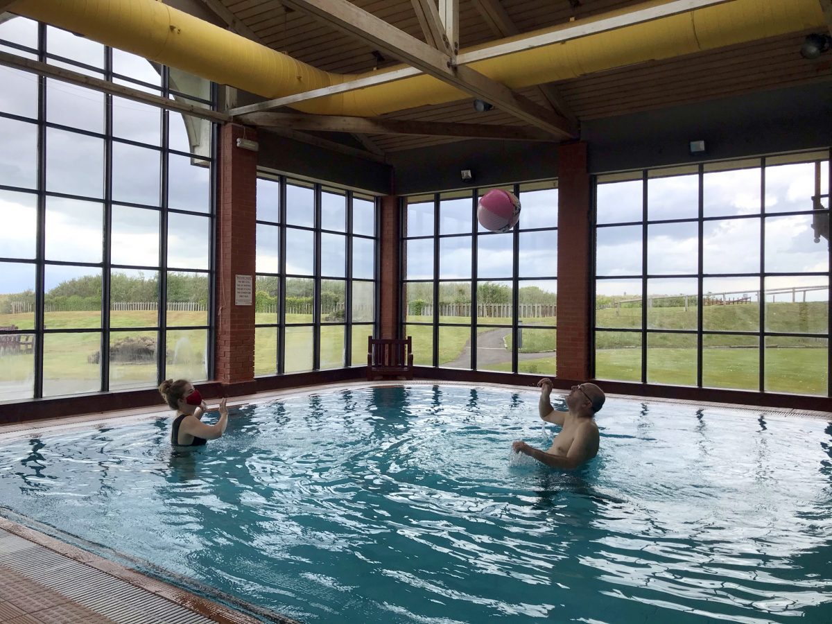 Revitalise guest and volunteer playing ball in the hydrotherapy pool