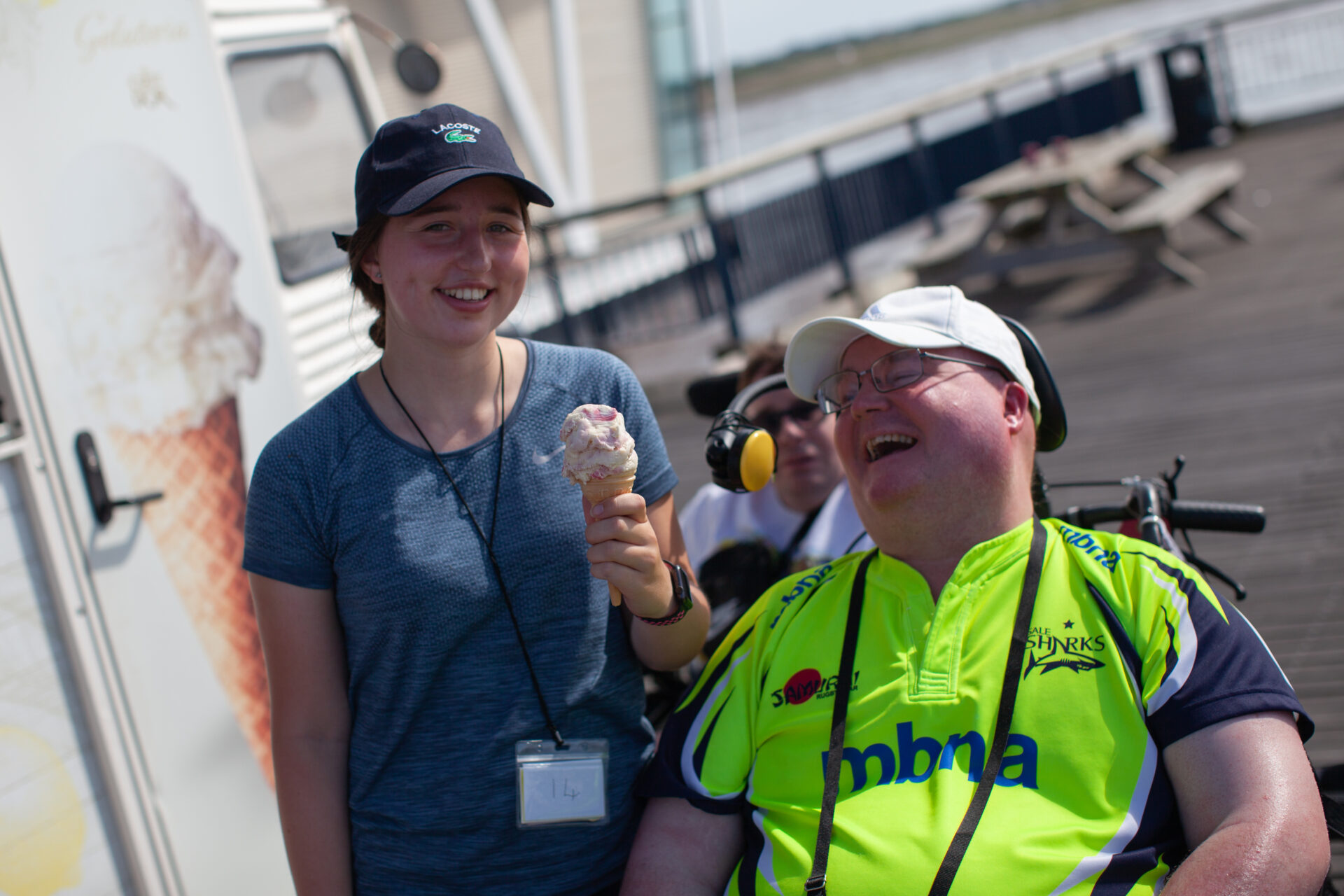 Man in wheelchair getting an ice cream in Southport with a young woman volunteering for Revitalise
