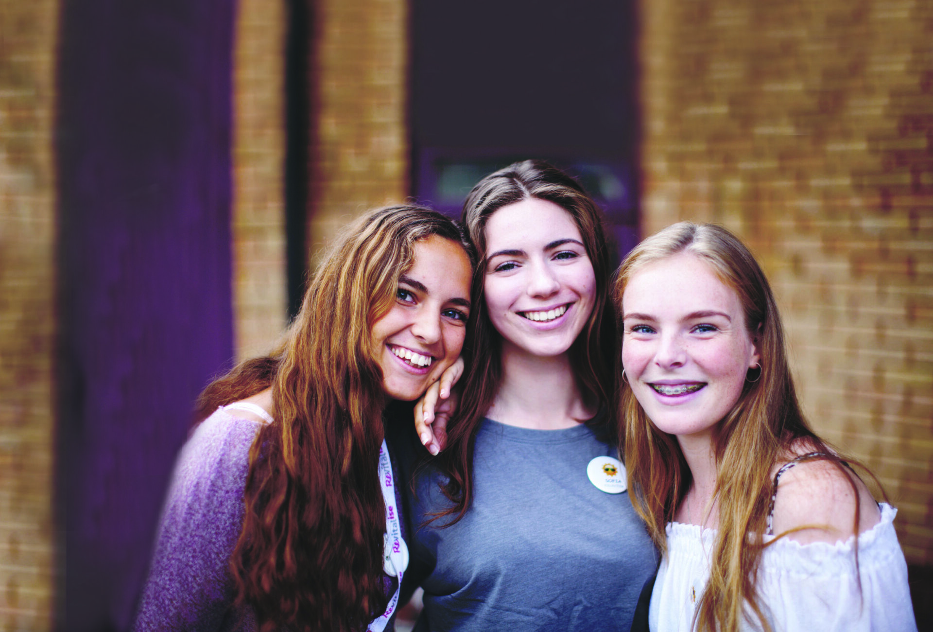 Group of three young women smiling at the camera while volunteering at Revitalise Jubilee Lodge