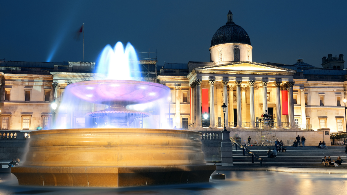 Image of Trafalgar Square and National Gallery at night.