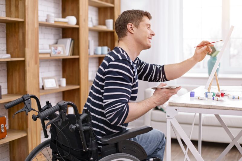 Young man in wheelchair painting