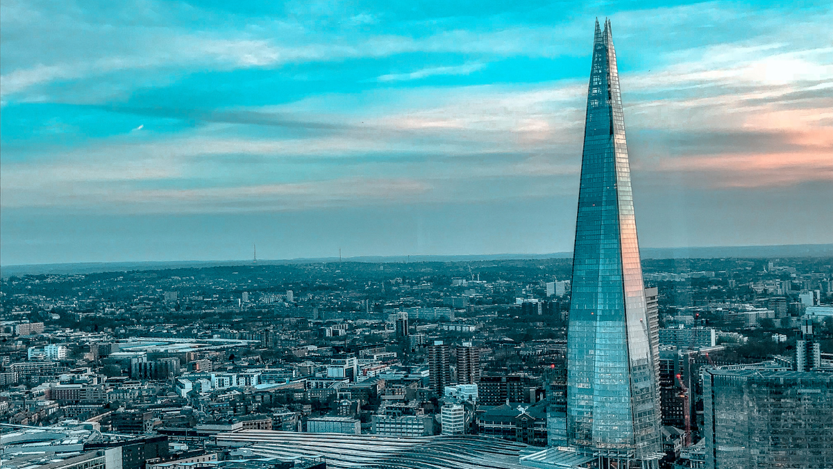A panoramic view of the London overlooking the city and its buildings. The skyscrapper The Shard stands tall amidst other buildings.