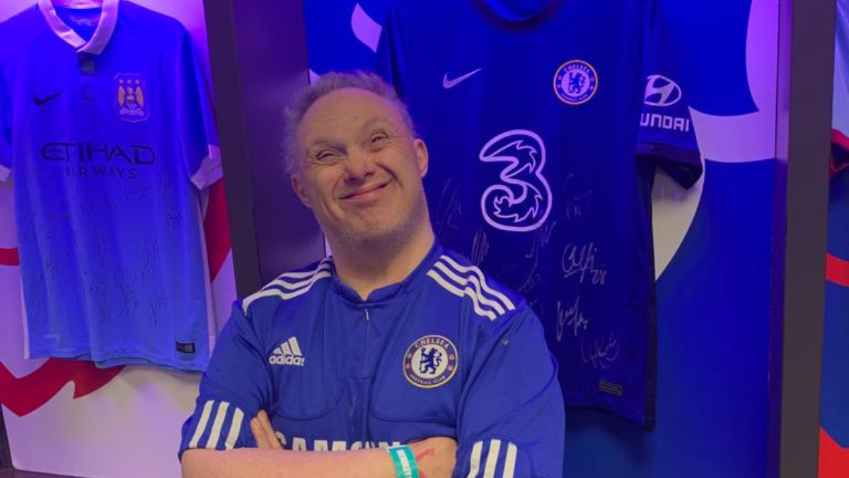 A guest from Jubilee Lodge smiling at the camera while wearing a Chelsea jersey and enjoying a stadium tour