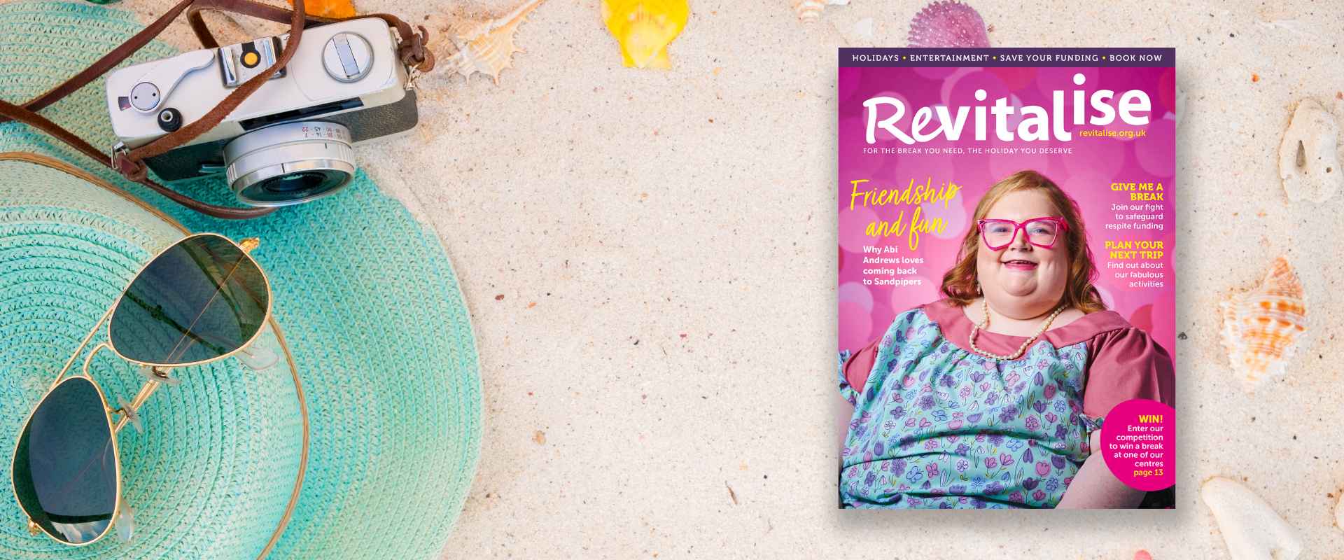 Close up image of sand on a beach along with a sun hat and a camera, suggesting holidays. An image of the front cover of Revitalise spring 2024 magazine is overlayed.