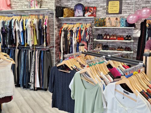 Image of the newly opened discount outlet store for Revitalise charity. The image shows neatly displayed clothes and other items.