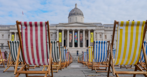 129 deck chairs lined by at Trafalgar Square to signify that only 1 out of 129 unpaid carers is able to get respite support. The National Gallery can be seen in the background.